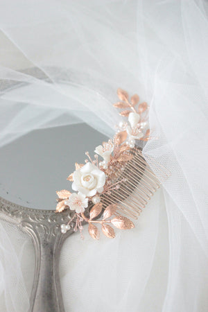 rose gold wedding hair piece for bride featuring clay flowers, pearls and crystals that can be worn on the side