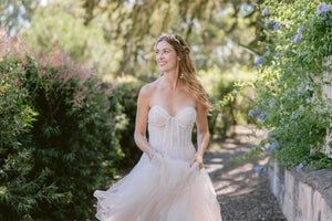 Bride wearing a wedding tiara and drop floral earrings with a  strapless wedding gown