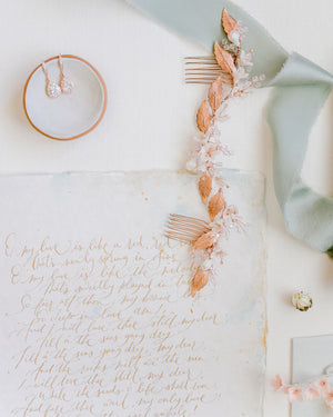 Flatlay with wedding details with stationery and rose gold hair piece and jewellery