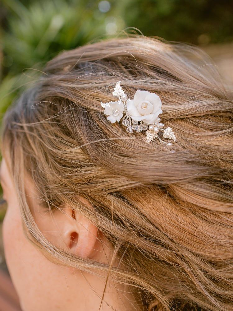 silver wedding hair piece for bride featuring clay flowers, pearls and crystals that can be worn on the side