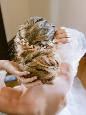 Bride putting on her wedding hair piece in her bridal updo, very romantic.