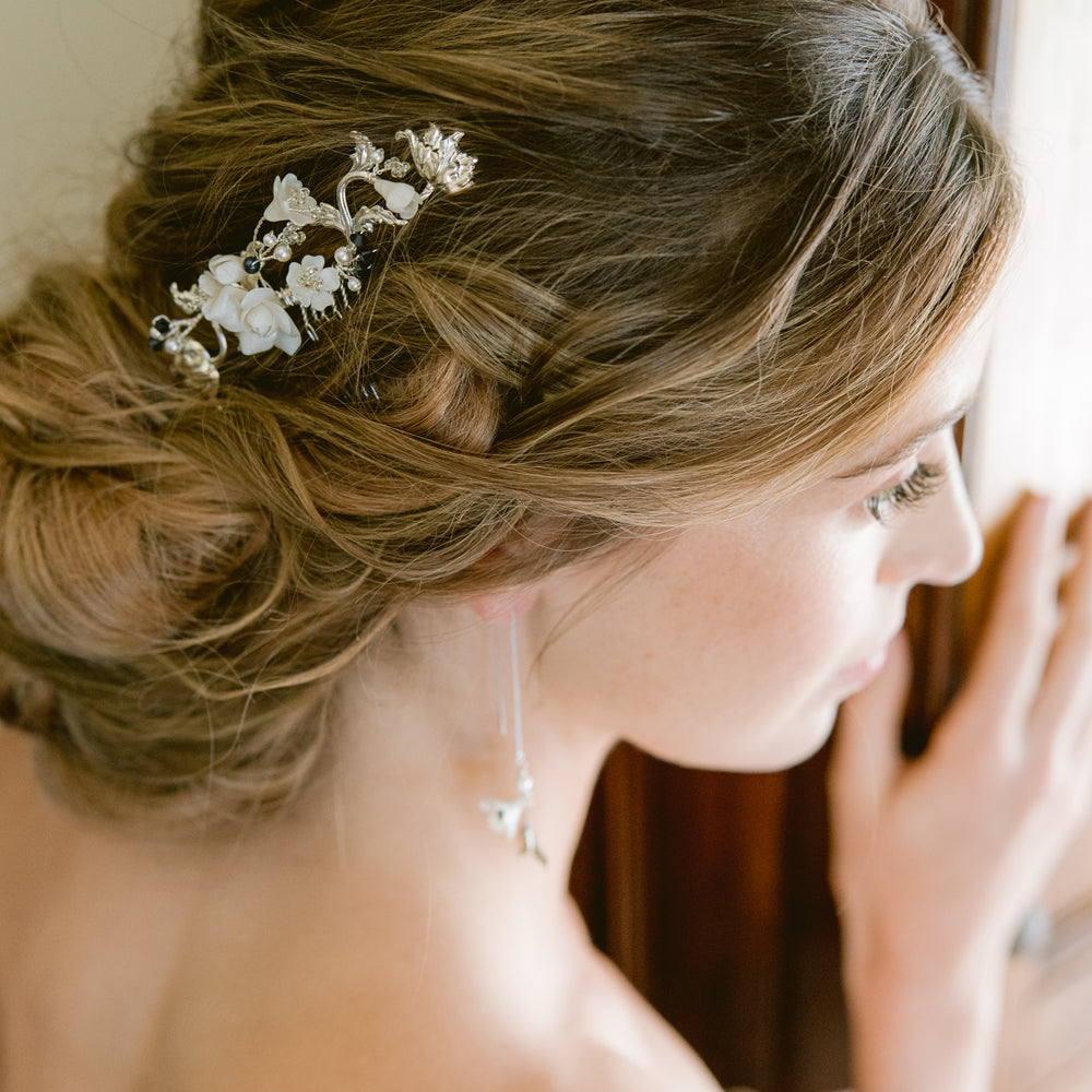 Bride wearing updo with silver bridal hair comb with roses, flowers, and blue pearls and crystals as something blue