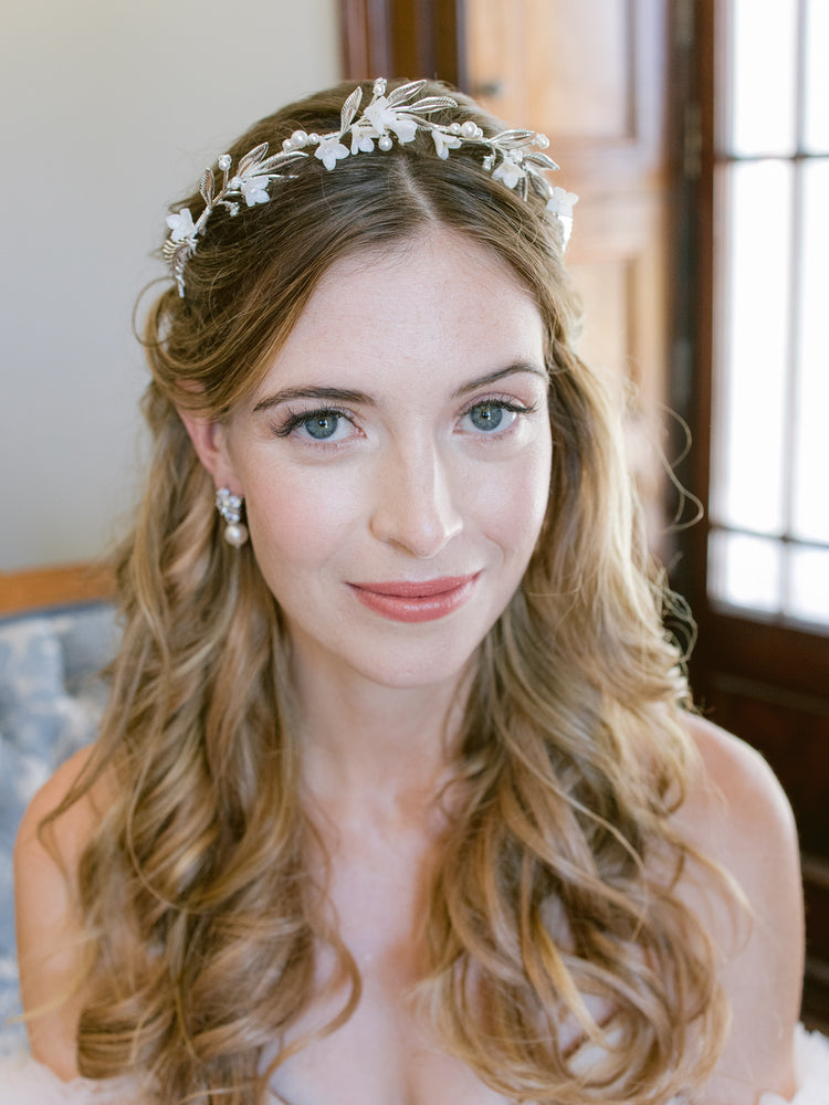 happy bride getting ready, wearing silver leaf and flower tiara with pearls and crystal stud earrings 